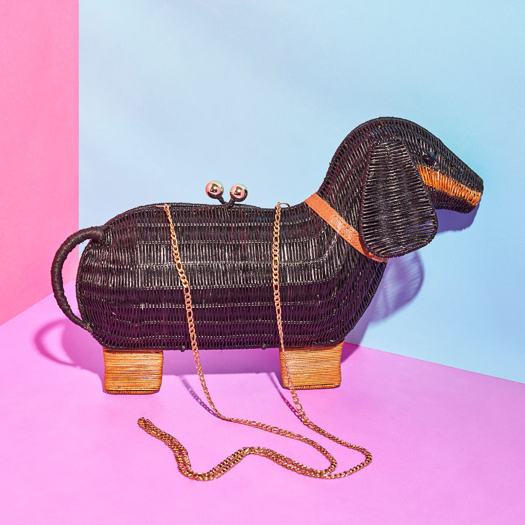 Animal shaped purse Sausage dog clutch bag sits in a colourful background