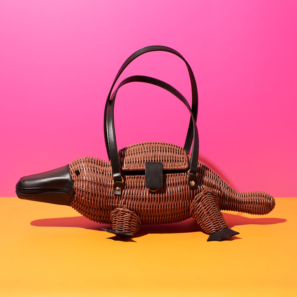 Animal shaped purse platpus bag wicker handbag australiana theme sits in a colourful background