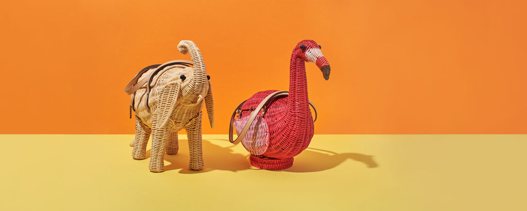 wicker darling elephant wicker bag and pink flamingo purse sits in a colourful bacground
