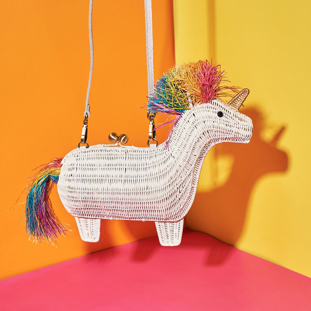 Wicker Darling Victoria the Unicorn shaped purse for adults features a rainbow mane and sits in front of a colourful wall