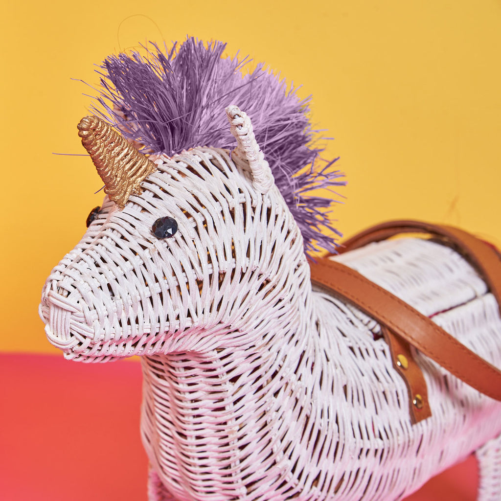 Wicker Darling Violet the purple unicorn purse for adults has a purple mane and sits in front of a colourful background