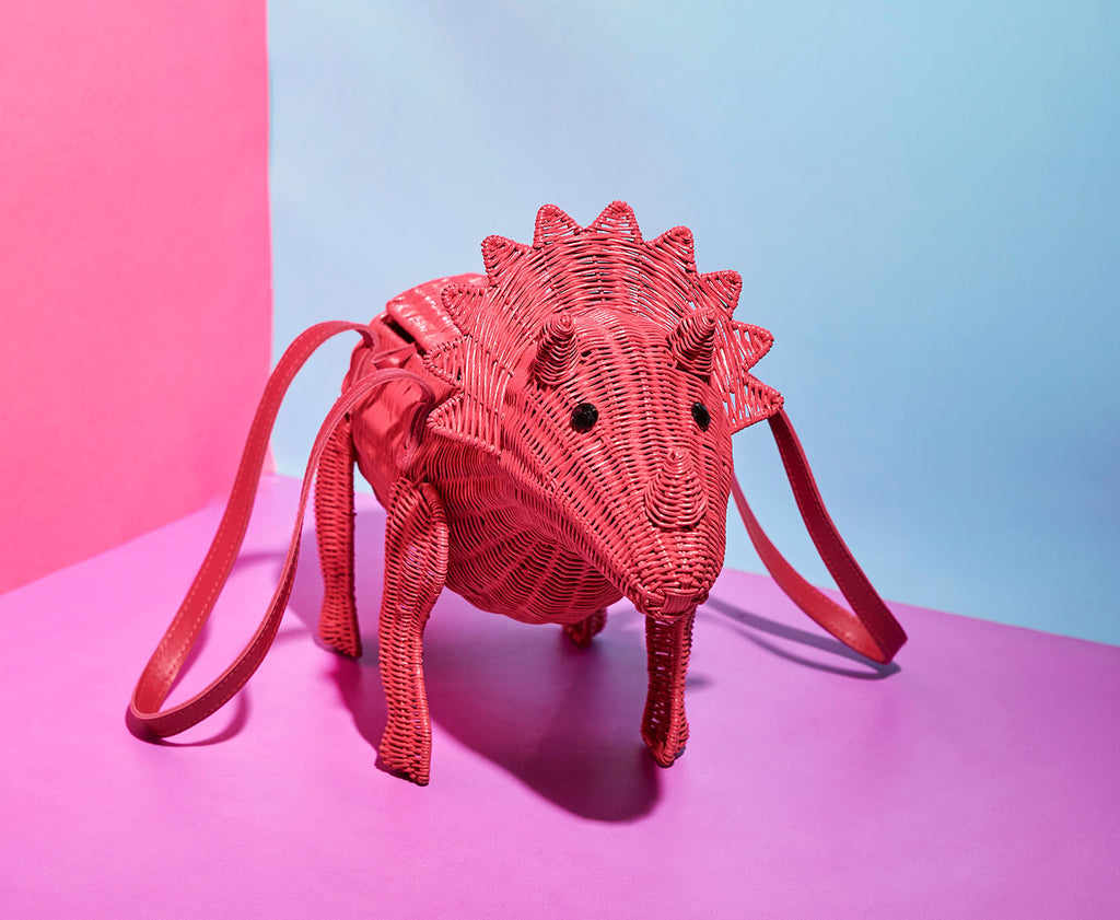 Animal Handbags Wicker Triceratops joan triceratops pink dinosuar handbag sits in a colourful pink background scene