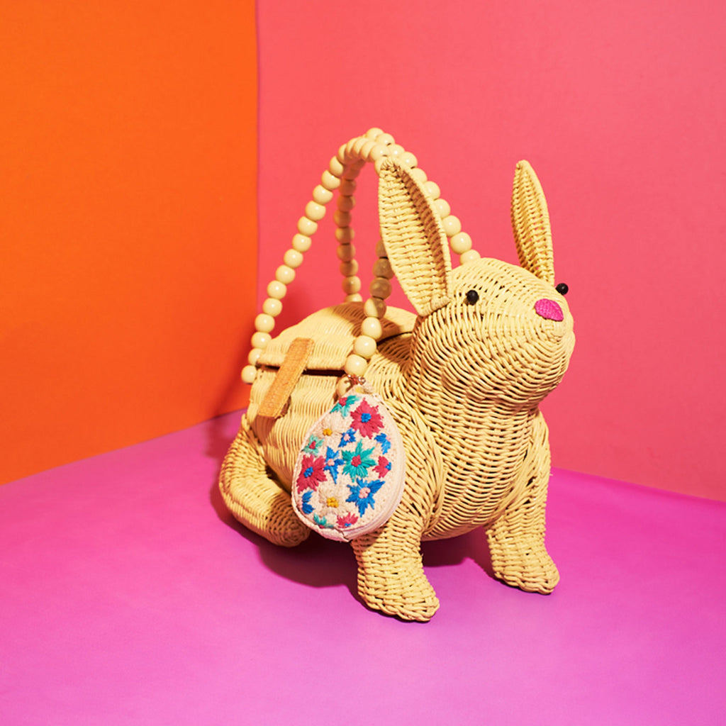 Wicker darling easter rabbit easter bunny purse vegan purse sits in a colourful room