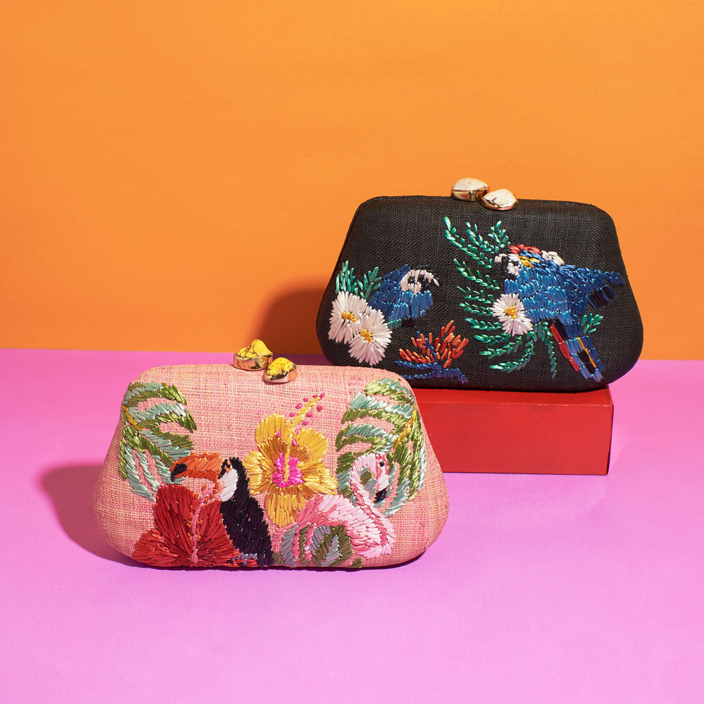 a set of small clutch bags by Wicker Darling sit in a colourful background
