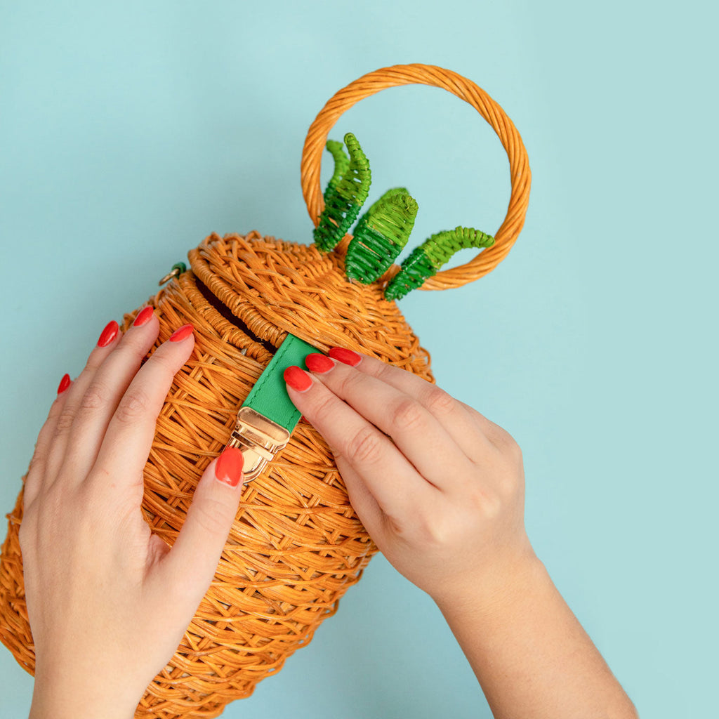 An image of the Wicker Darling fineapple pineapple purse sits in a blue coloured background