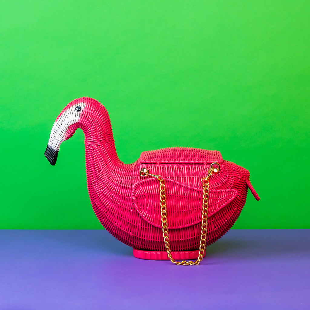 Wicker darling Andes the flamingo bag sits in a colourful background.