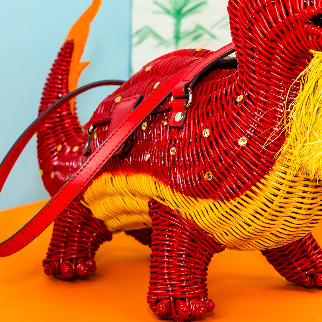 Wicker Darling Loong Dragon shaped bag design wicker handbag sits in a colourful background.