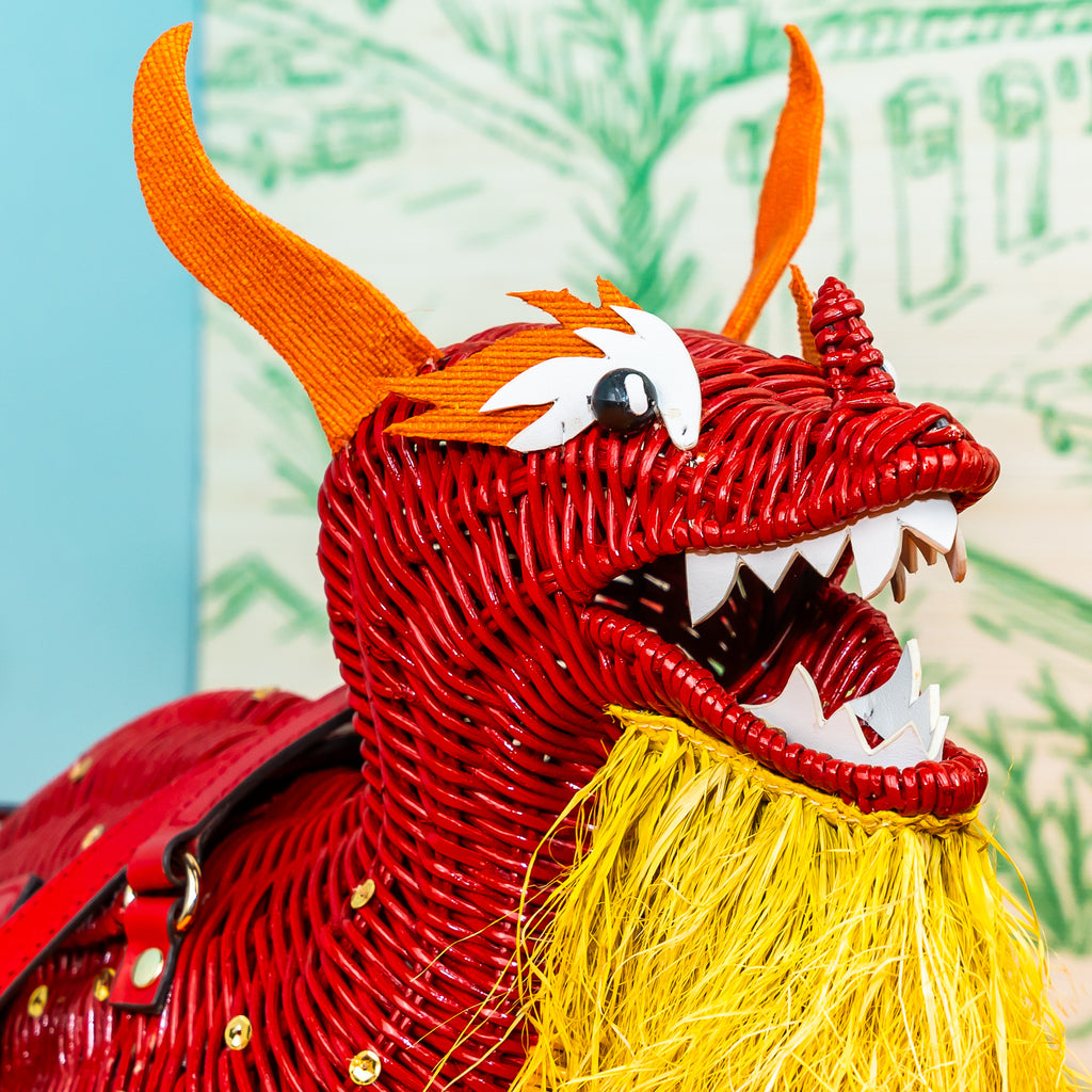 Wicker Darling Loong Dragon shaped bag design wicker handbag sits in a colourful background.