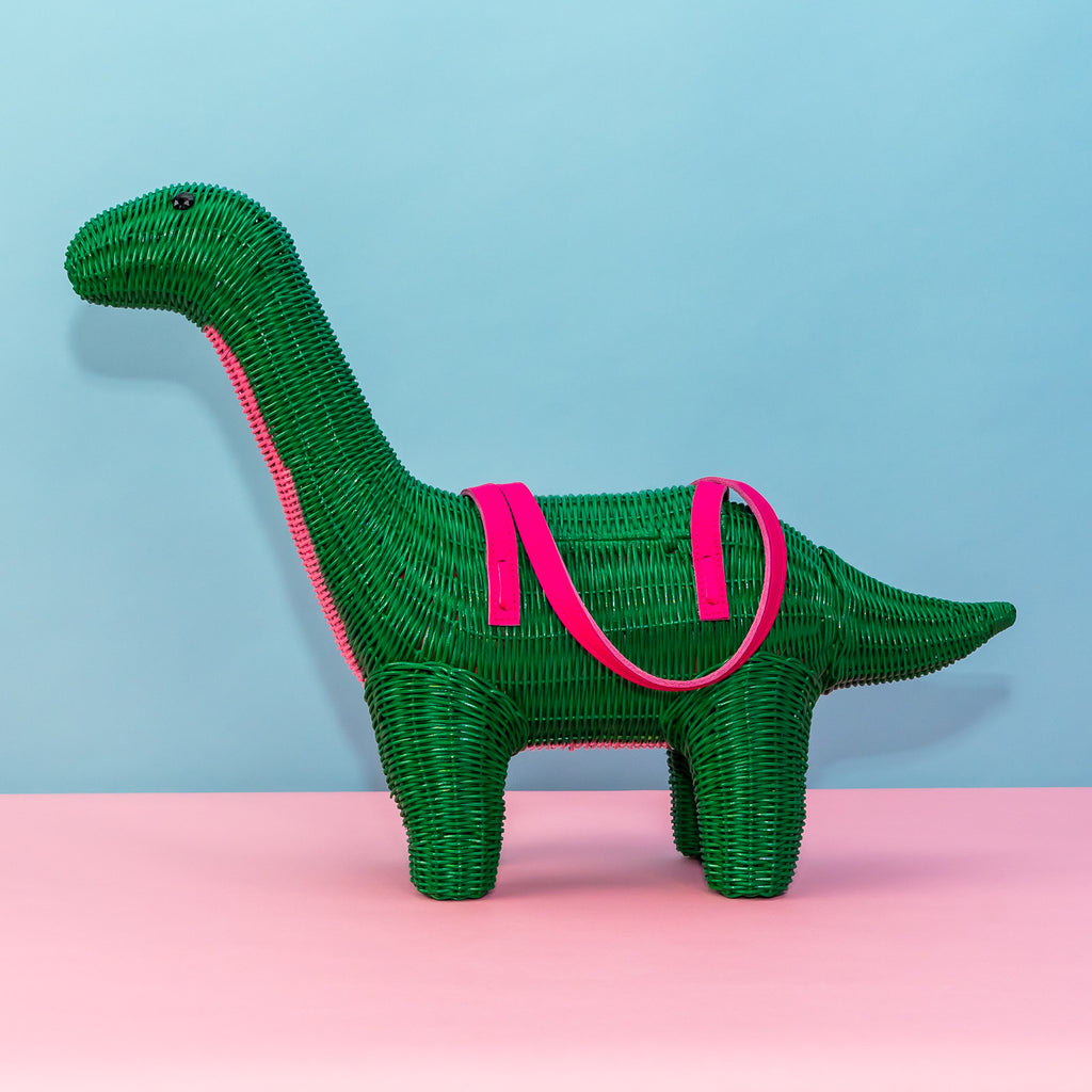 Wicker Darling green dinosaur purse patrick the bront-saurus stands in a colourful background.