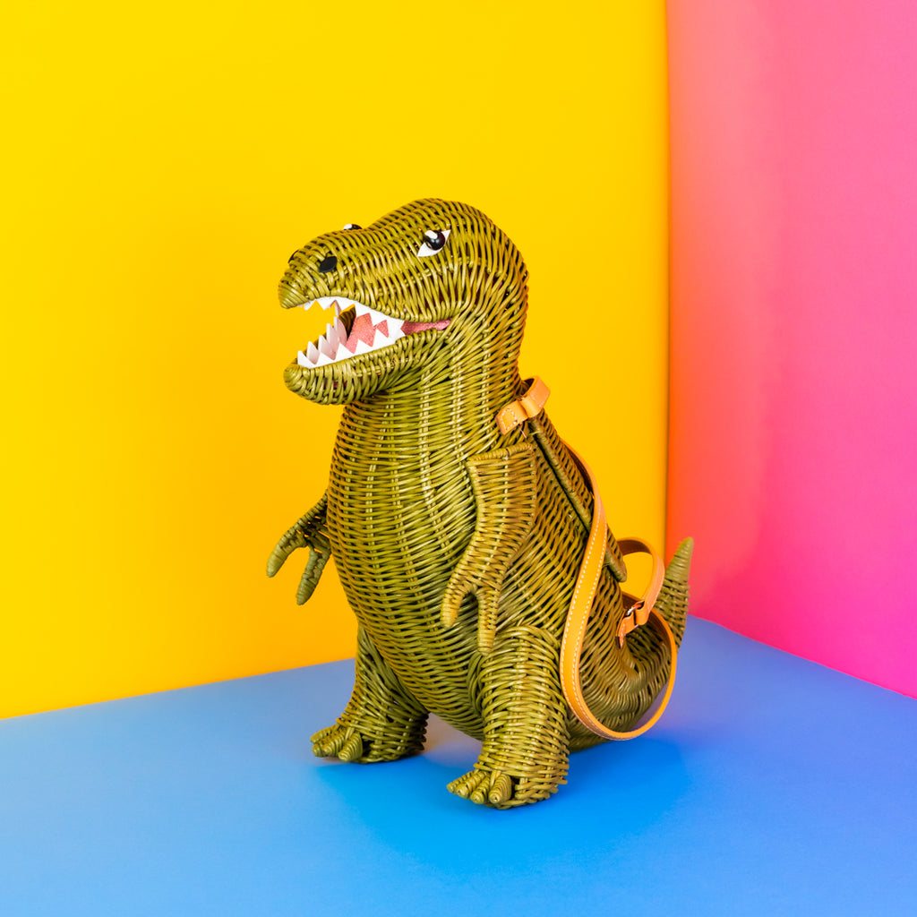 A green wicker t-rex handbag with tan handles.