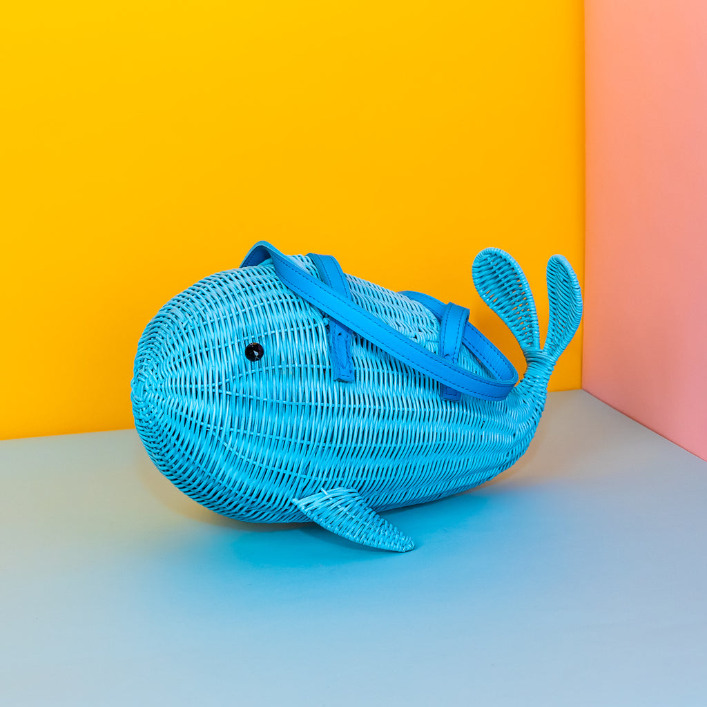 Wicker Darling Squirt whale handbag squirt purse sits in a colourful background.