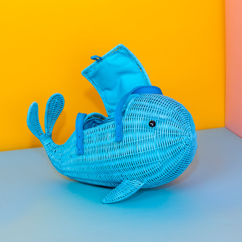 Wicker Darling Squirt whale handbag squirt purse sits in a colourful background.