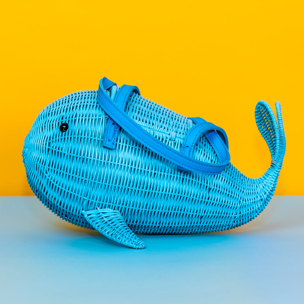 Wicker Darling Squirt whale handbag squirt purse sits in a colourful background.