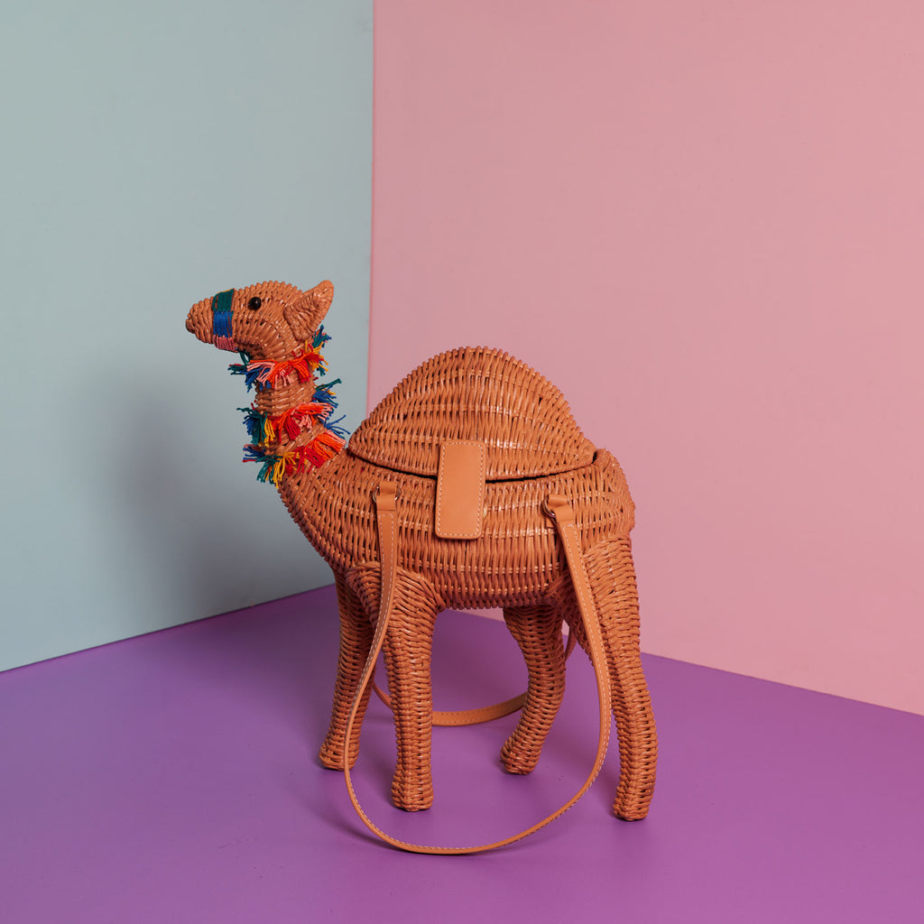 Wicker Darling Cyrus the Camel Purse sits in a colourful background