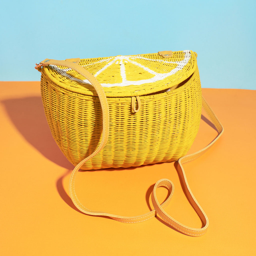Lemon fruit shaped purse fruit handbag sits in a colourful background