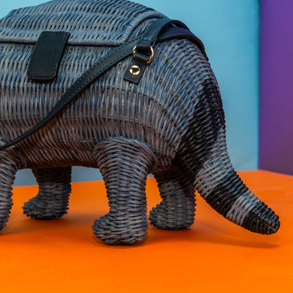 Wicker Darling wicker raccoon handbag raccoon purse features handmade wicker details and sits in a colourful room. 