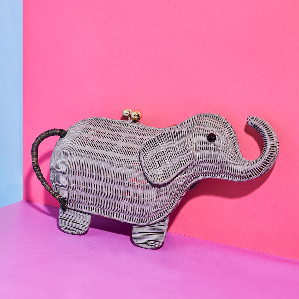 Animal shaped purse elephant shaped bag wicker purse sits in a colourful background