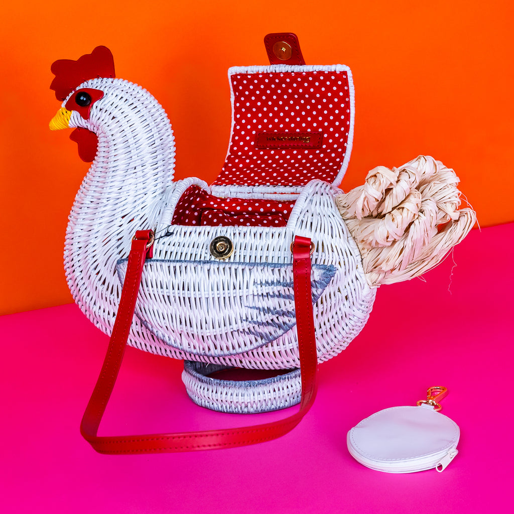 Wicker darling white chicken handbag chicken purse has red detailing and sits in a colourful background.