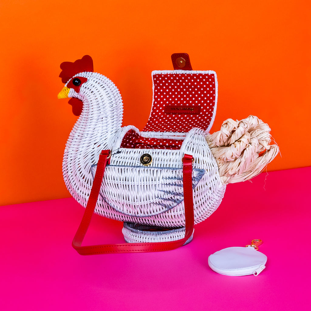 Wicker darling white chicken handbag chicken purse has red detailing and sits in a colourful background.