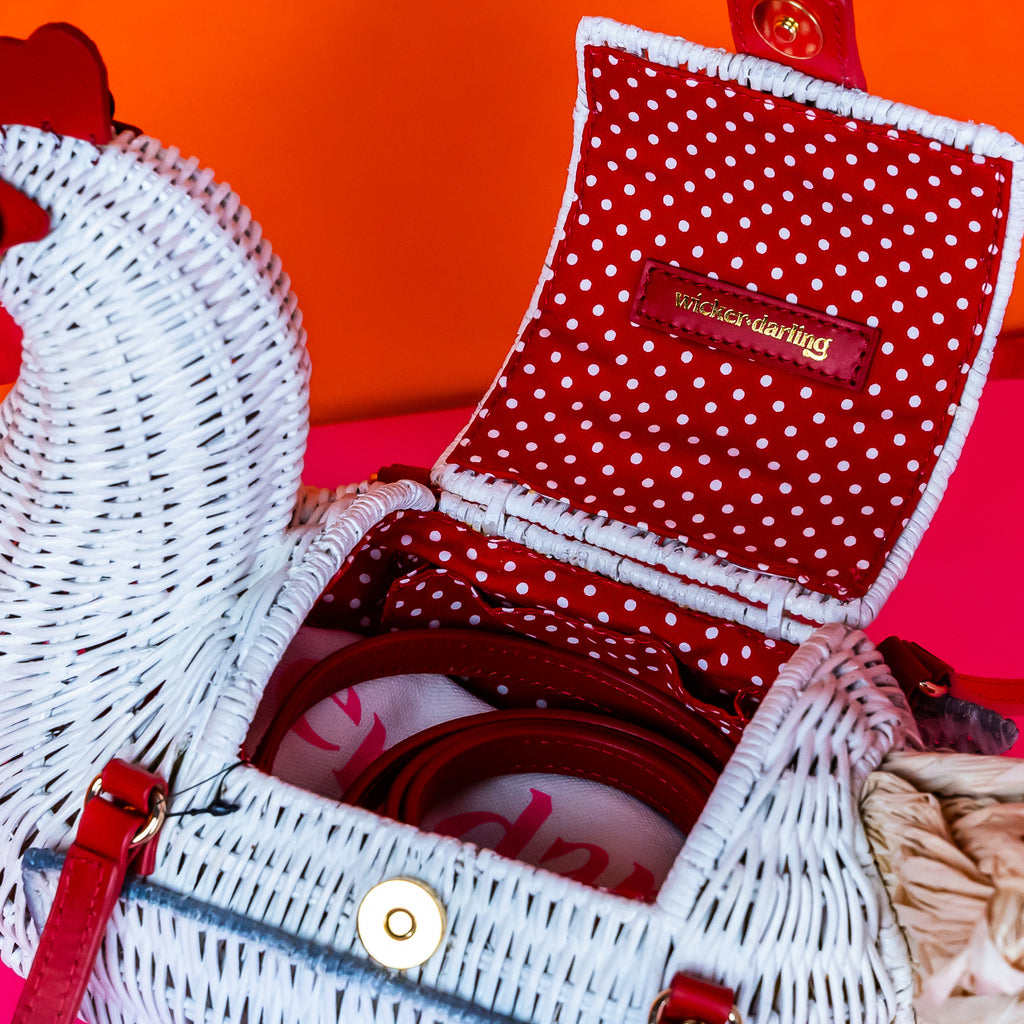 Wicker darling white chicken handbag chicken purse has red detailing and sits in a colourful background.