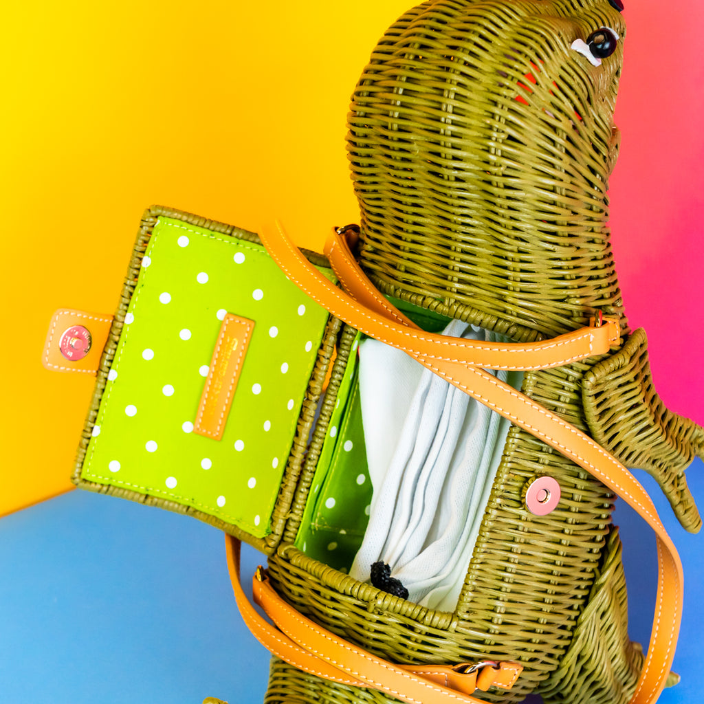 Inside the compartment of the trex handbag. It has lime green lining with white polka dots. There's a dustbag inside the t-rex.