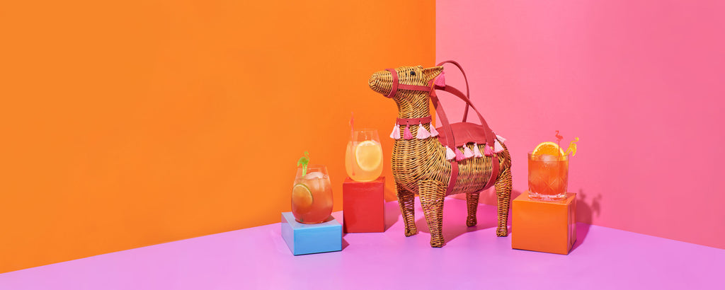 wicker darling lola the llama bag llama wicker bag is a quirky purse that sits with cocktails in a colourful room, made by Australian designers