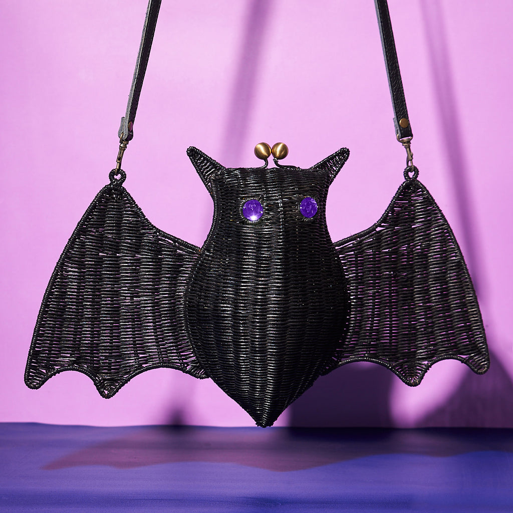 Wicker Darling Cpount Batula bat handbag sits in a colourful background.