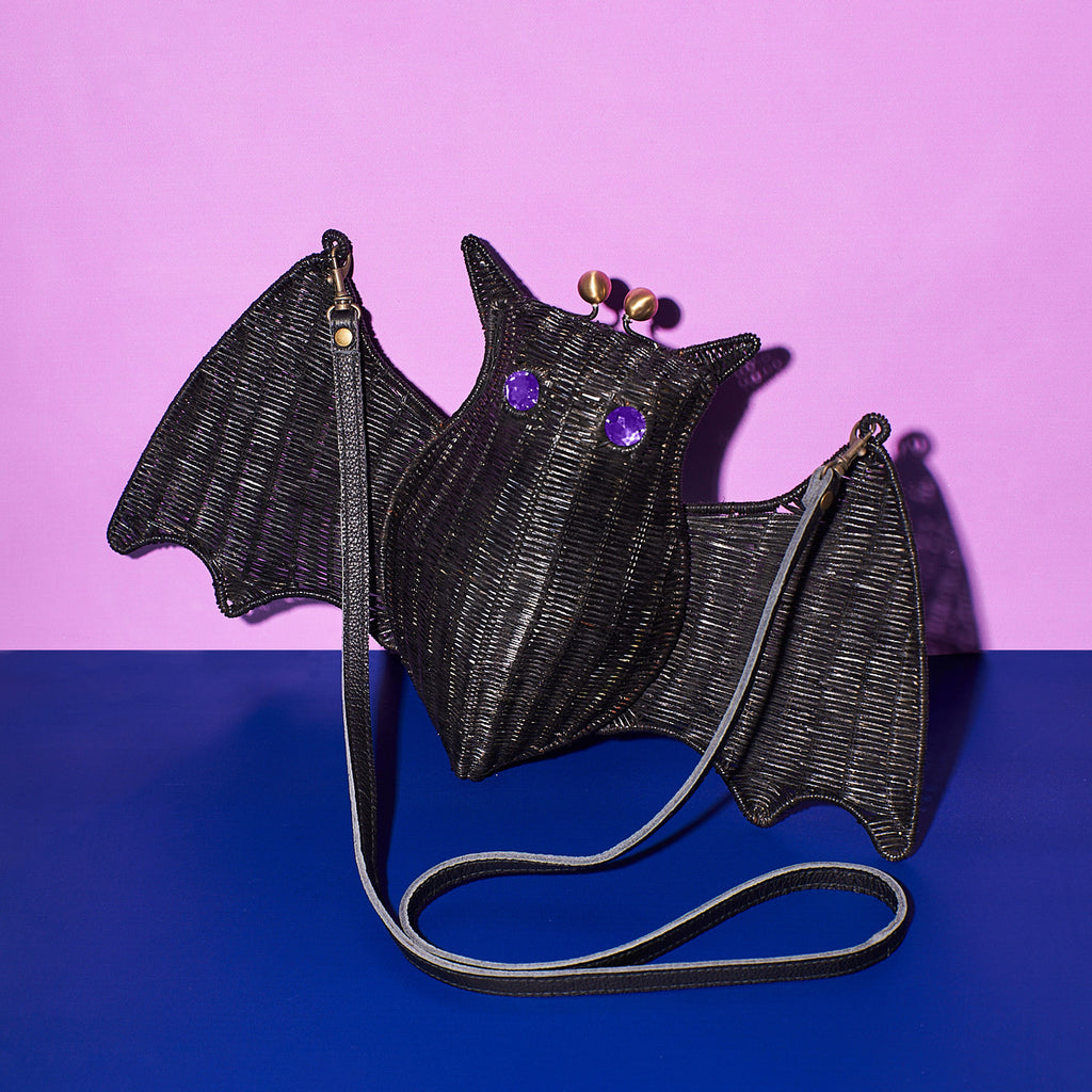 Wicker Darling Cpount Batula bat handbag sits in a colourful background.