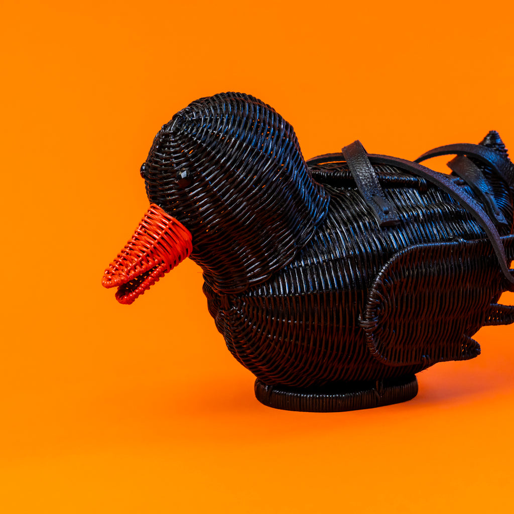 Side profile of black rattan rubber duck  bag with orange beak.