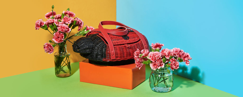 wicker darling lugabug the ladybug purse ladybird handbag sits with fresh flowers in a colourful background, made by Australian Designers