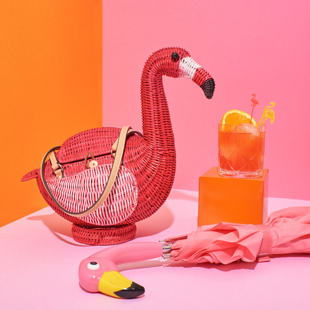 Wicker Darling monty flamingo shaped bag flamingo wicker basket sits in a colourful pink background