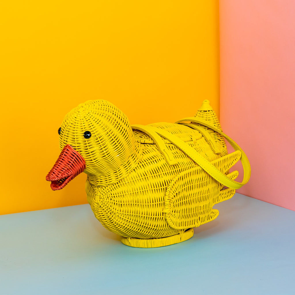 Wicker Darling yellow rubber duck handbag rubber duck purse sits in a colourful background.