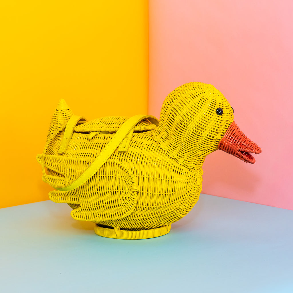 Wicker Darling yellow rubber duck handbag rubber duck purse sits in a colourful background.