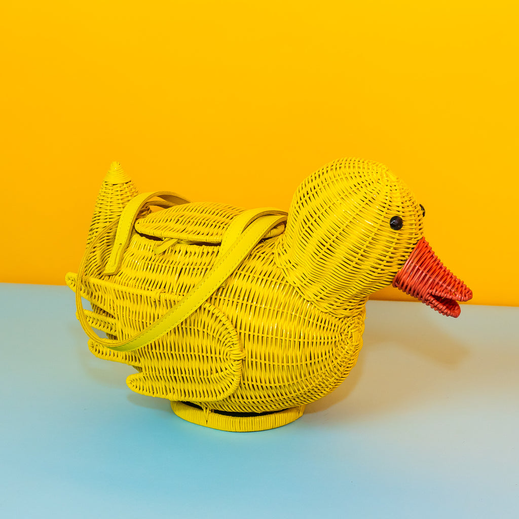 Wicker Darling yellow rubber duck handbag rubber duck purse sits in a colourful background.