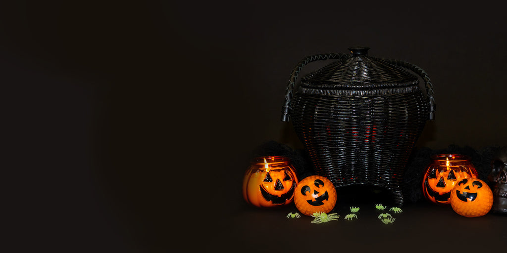 Wicker Darling cauldron shaped purse sits in a black background. 