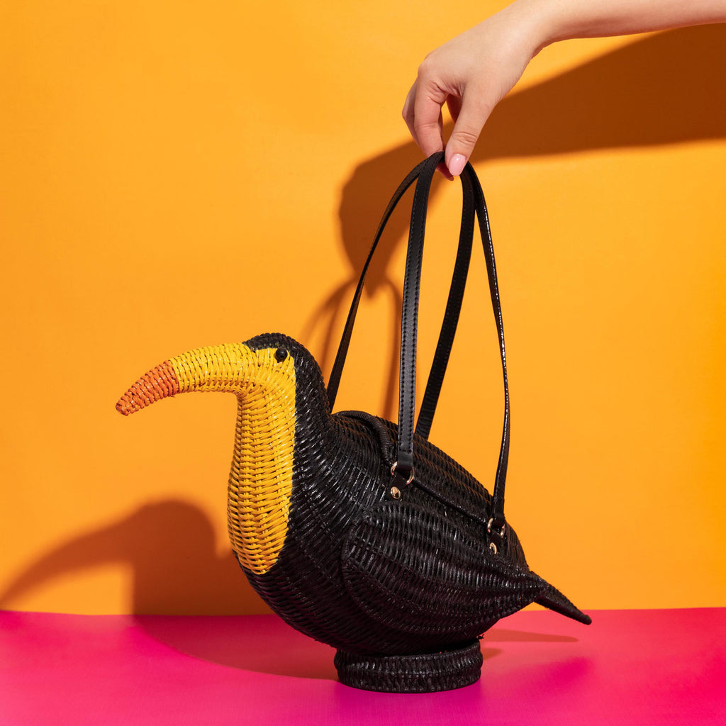 Wicker Darling black Toucan purse toucan bag in a colourful room