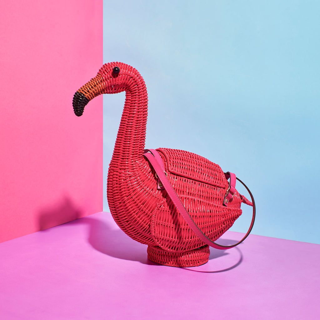 Wicker Darling flamenco flamingo handbag sits in a colourful room