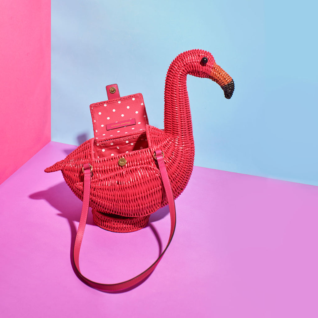 Wicker Darling flamenco flamingo handbag sits in a colourful room