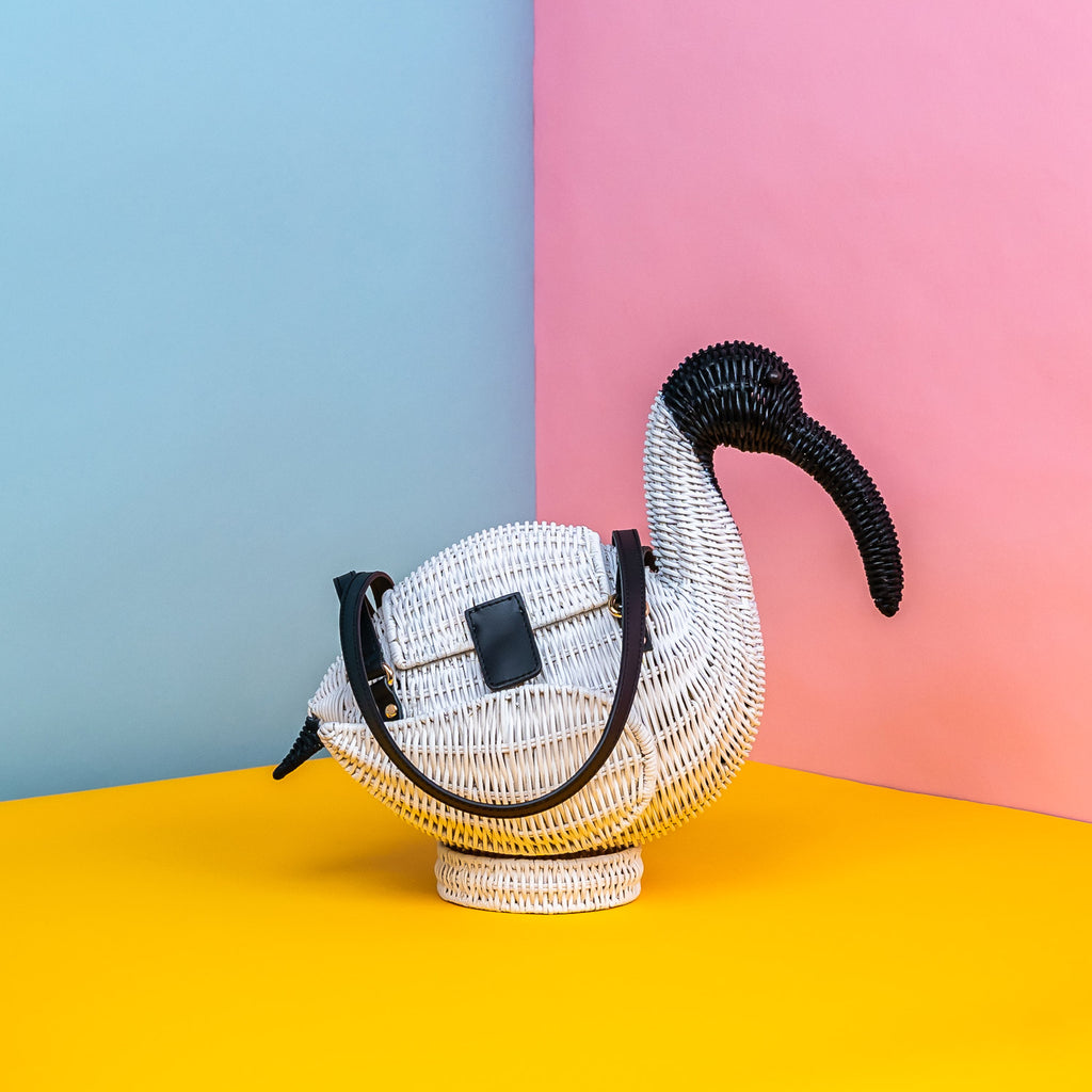 Wicker Darling Iris the Ibis purse sits in a colourful background