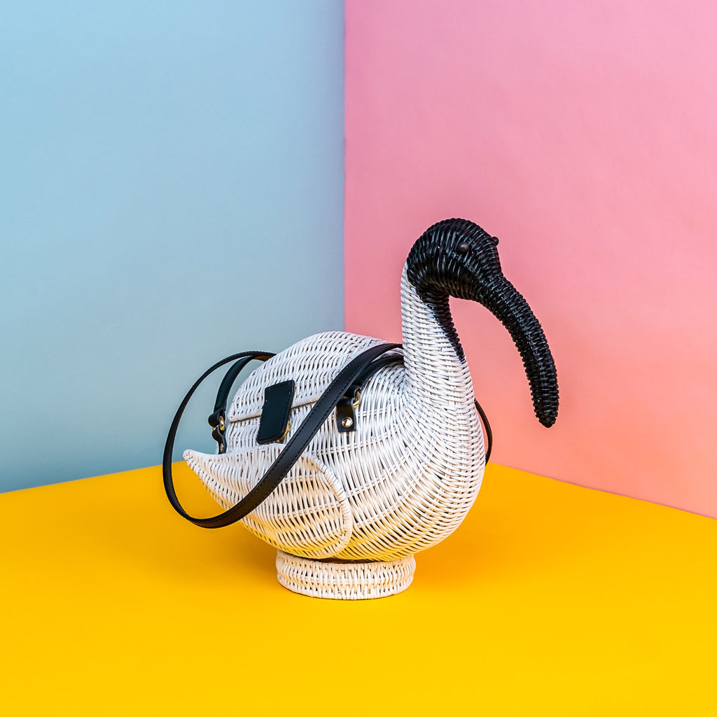 Wicker Darling Iris the Ibis purse sits in a colourful background