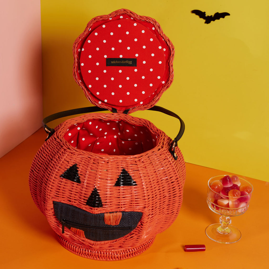 Wicker Darling jack-o-lantern wicker bag pumpkin shaped purse sits in a colourful room