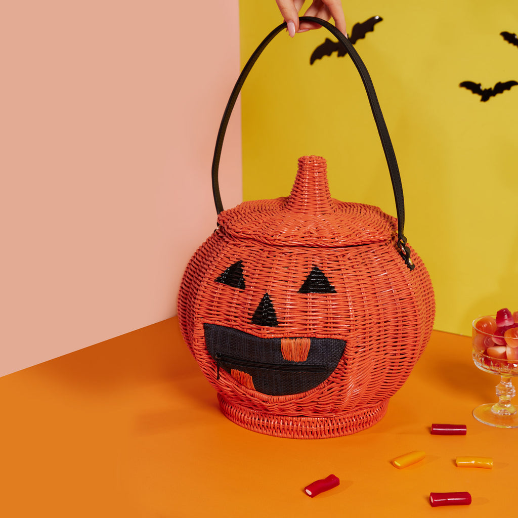 Wicker Darling jack-o-lantern wicker bag pumpkin shaped purse sits in a colourful room