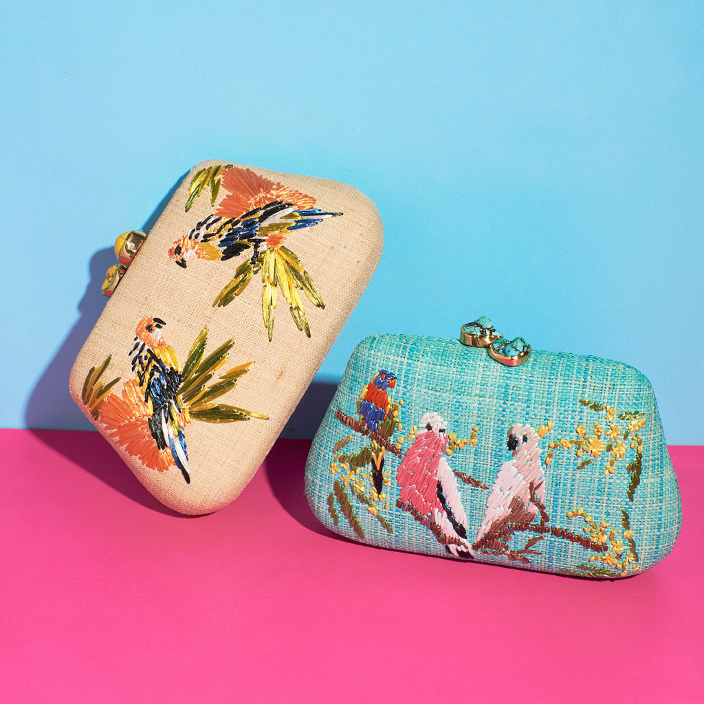Wicker darling australiana theme fabric clutch bag with galah lorikeet and cockatoo sits on a colourful background