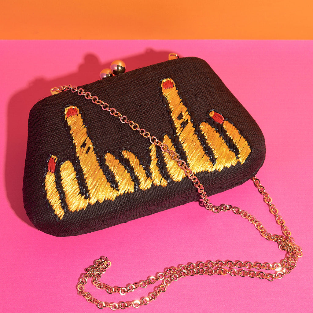 Wicker darling rude middle finger bag fabric embroidered clutch sits in a colourful background