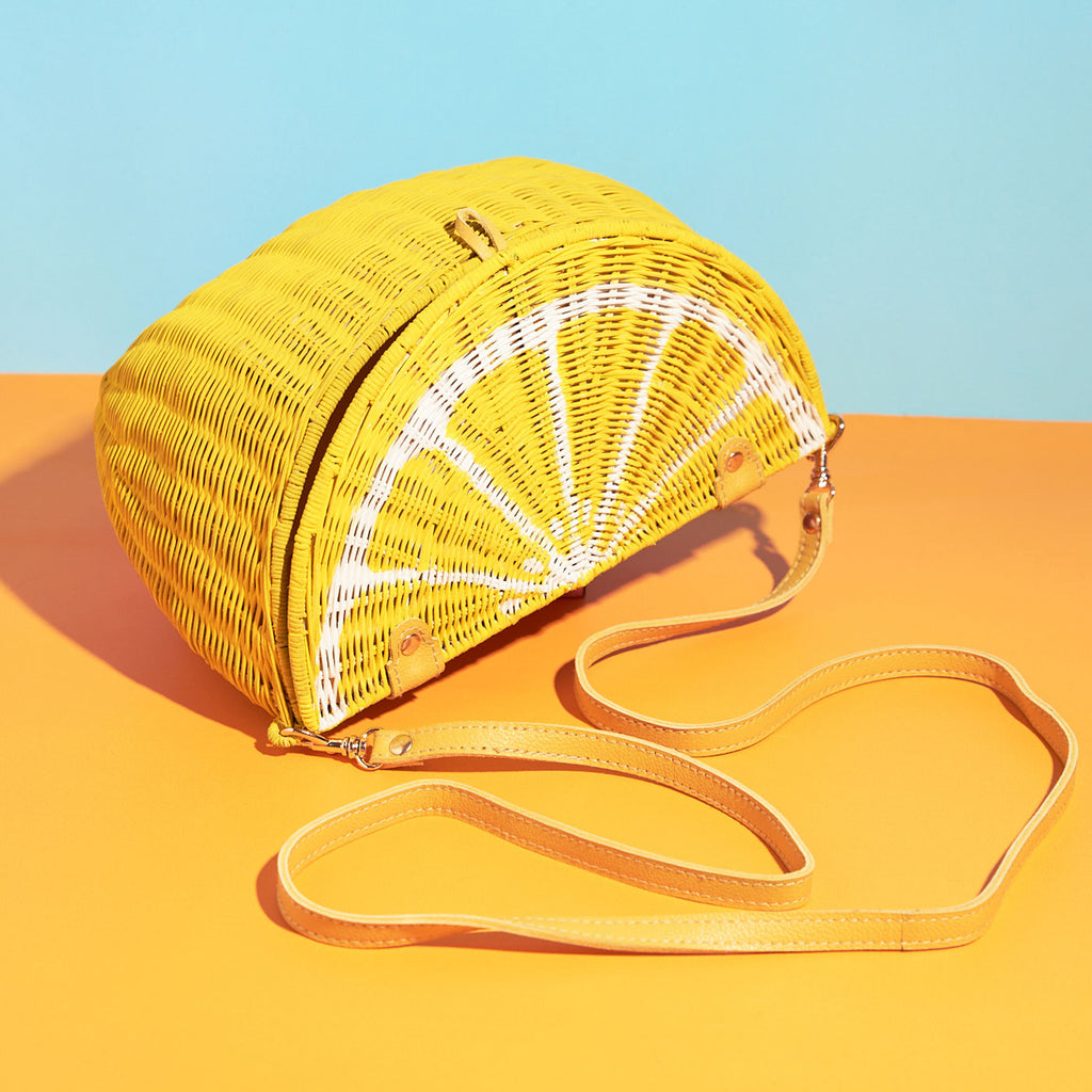 Wicker Darling mini lemon shaped purse lemon bag sitting in a colourful backkground