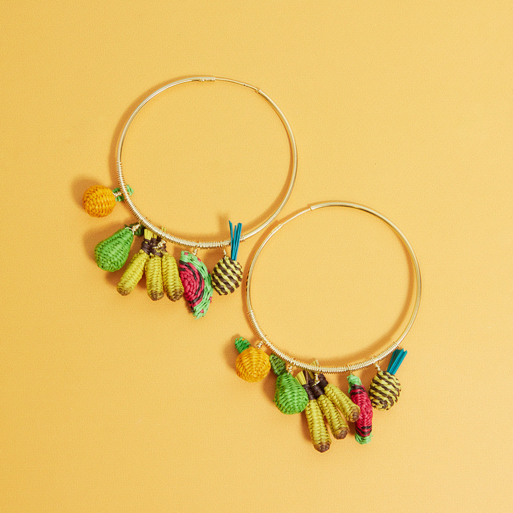wicker darling hand woven fruit salad hoop earrings sit in a colourful background