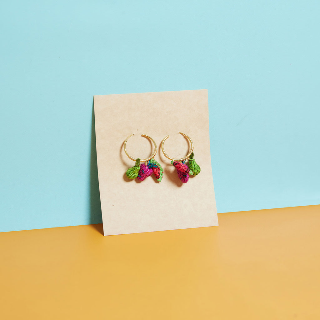 wicker darling hand woven fruit salad hoop earrings sit in a colourful background