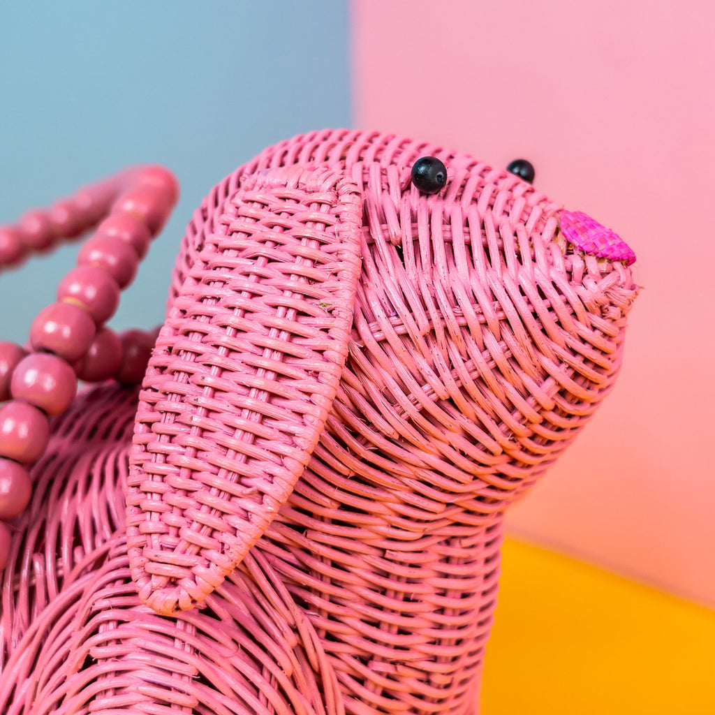 Wicker Darling Usagi pink rabbit handbag sits in a colourful background