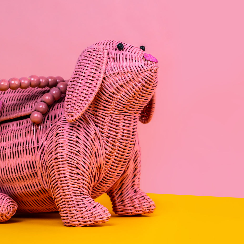 Wicker Darling Usagi pink rabbit handbag sits in a colourful background