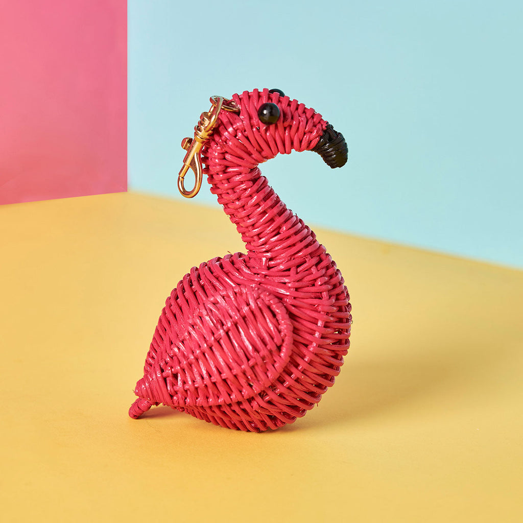 Wicker Darling wicker flamingo charm sits in a colourful background